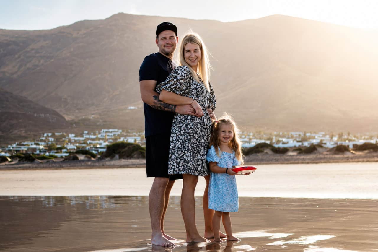 Familie beim Posing während eines Lanzarote-Fotoshootings am Strand bei Sonnenuntergang mit einem professionellen Fotografen auf Lanzarote.