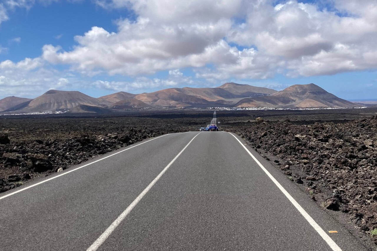 Trike riding a straight road through the lava fields of Lanzarote