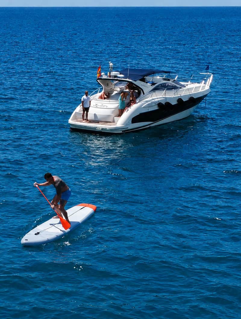 Guests paddleboarding from a private yacht on a Los Gigantes yacht trip in Tenerife.