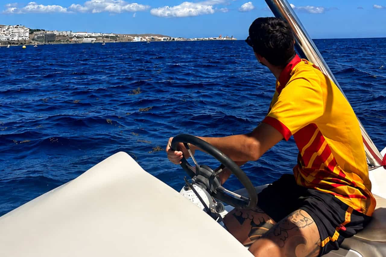 Parasailing boat on the Atlantic Ocean with a colourful parasail flying above the coast of Gran Canaria.