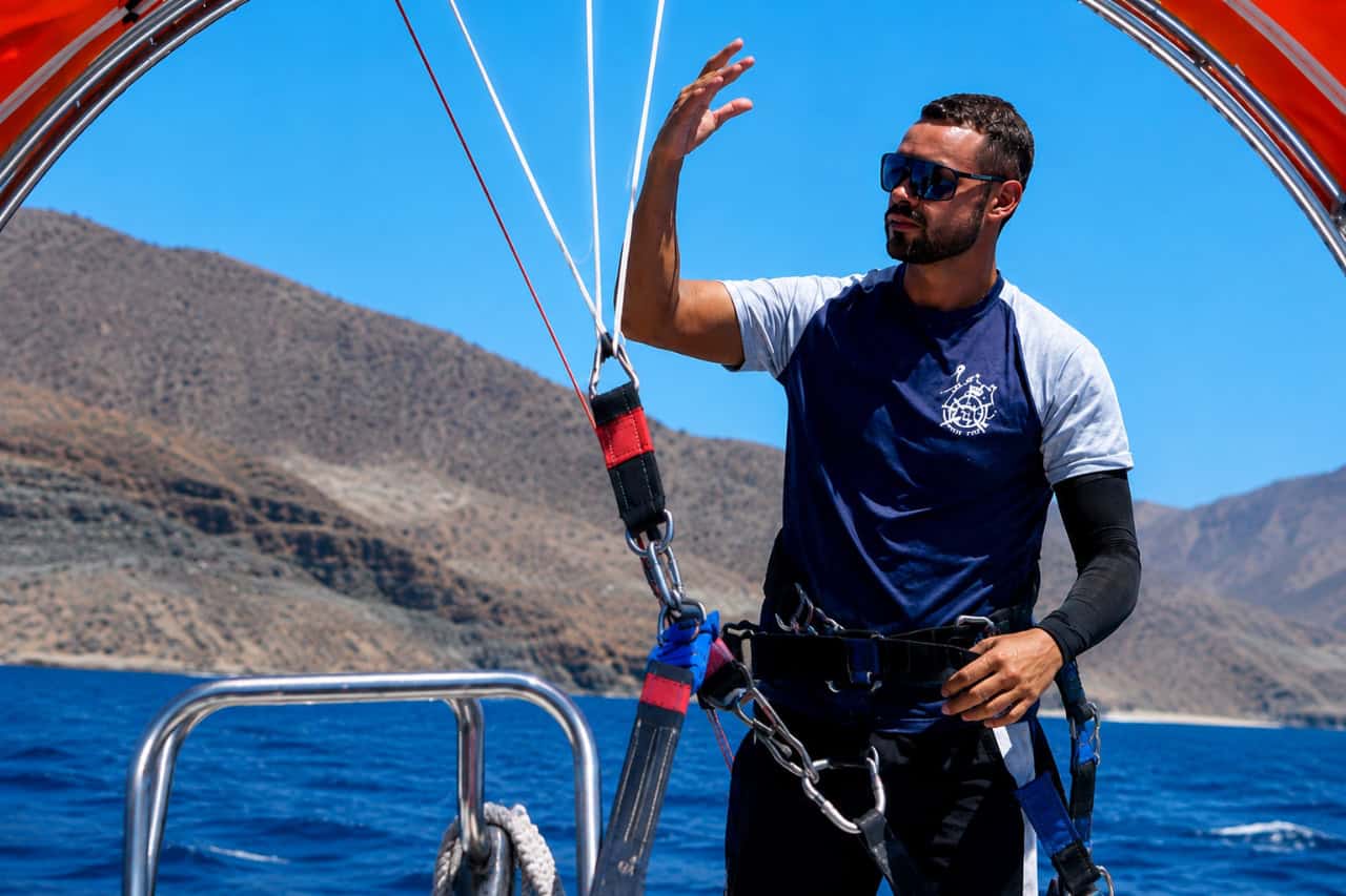 Parasailing instructor preparing safety harnesses and equipment on a boat in Gran Canaria.
