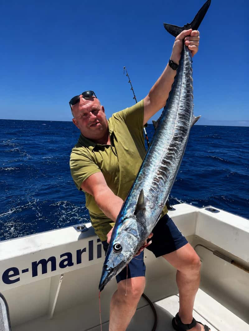 Guest holding a large fish during a private deep sea fishing charter in Gran Canaria