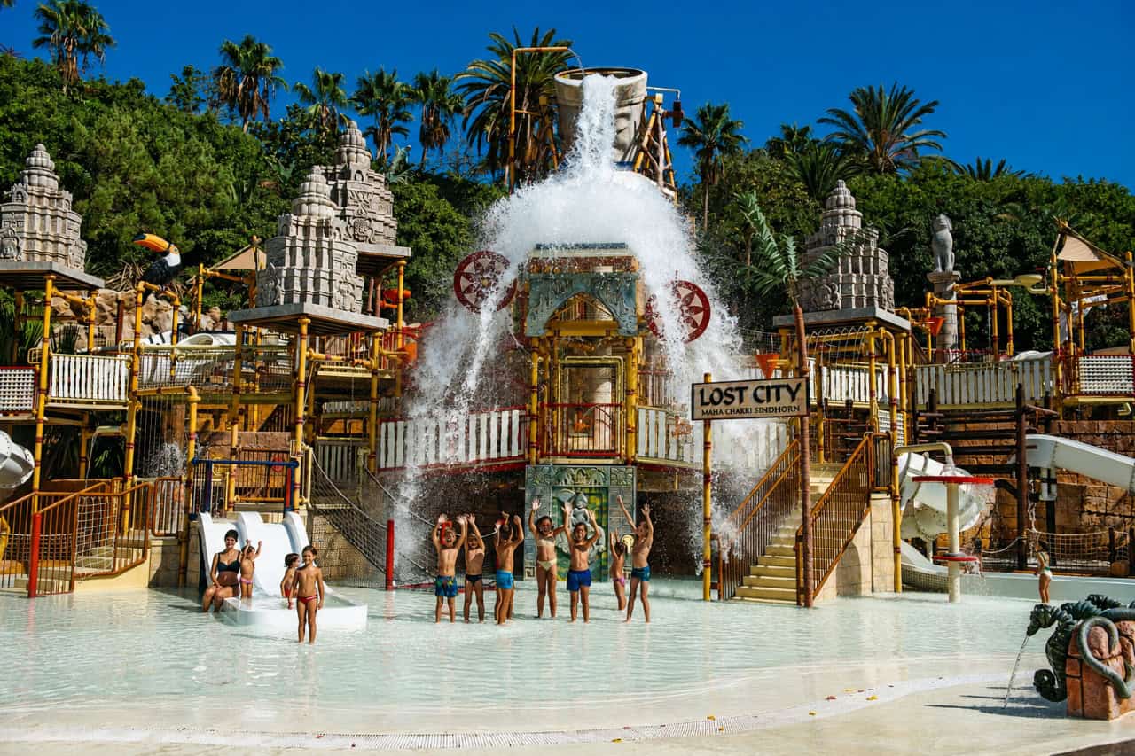 Bērni spēlējas zem Siam Park "Pazaudētās pilsētas" ūdens atrakciju konstrukcijām