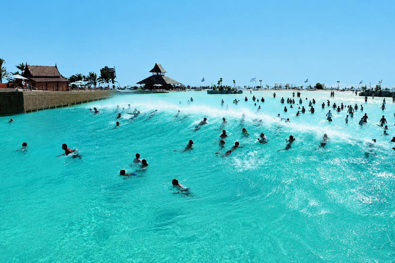 Apmeklētāji peld cauri lielam mākslīgajam vilnim Siam Park parkā