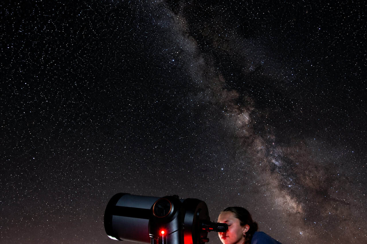 Guest viewing the night sky through a telescope in Teide