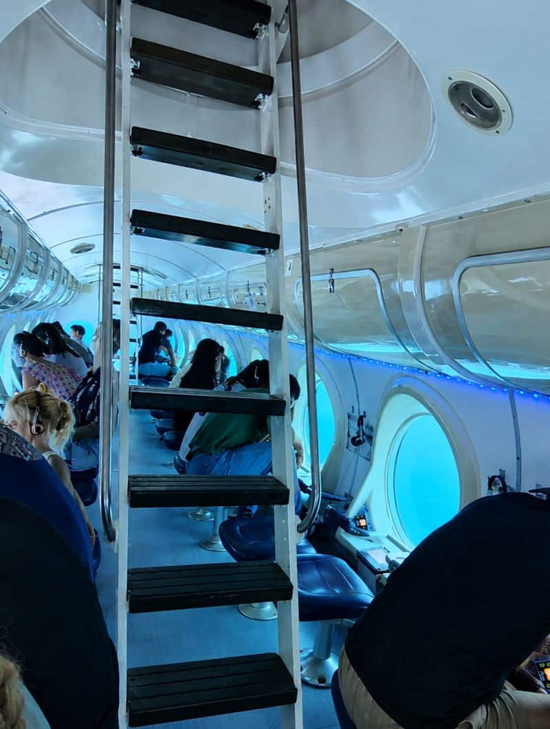 Im Inneren der Kabine der Teneriffa-U-Boot-Tour, mit Fensterplätzen an beiden Seiten und der zentralen Leiter