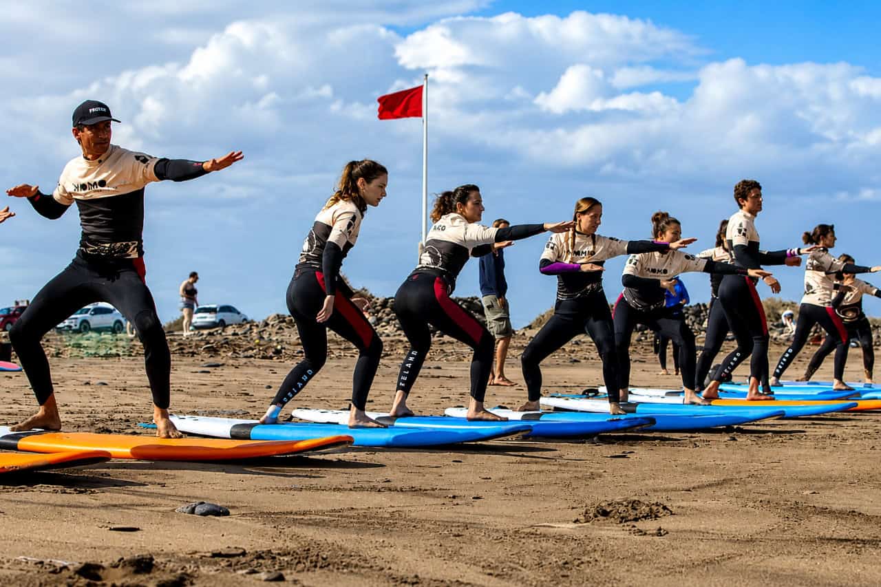 Student riding a wave during surf lessons at Famara in Lanzarote