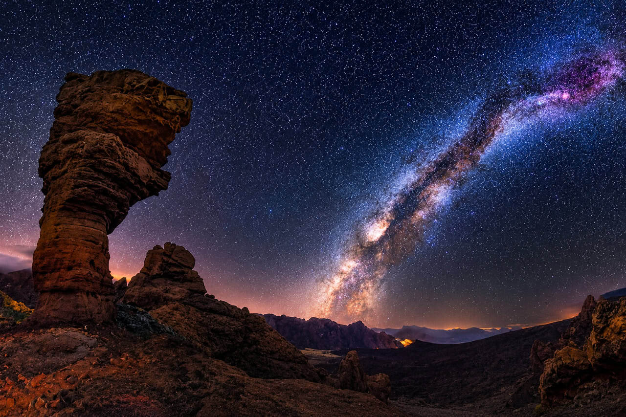Milky Way stretching above dramatic volcanic rock formations on Mount Teide at night