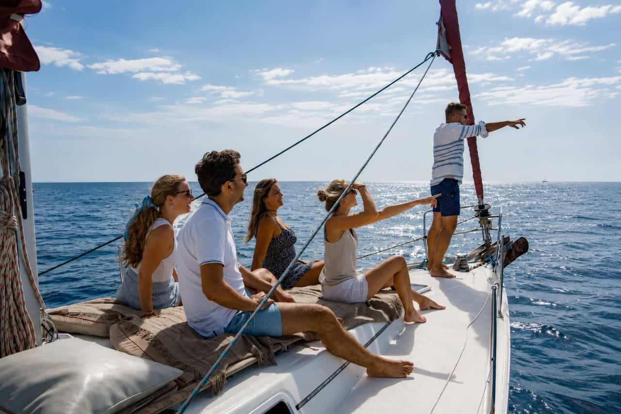 Guests pointing towards whales and dolphins from the deck during a private Atlantic Star sailing charter along Tenerife’s south coast.
