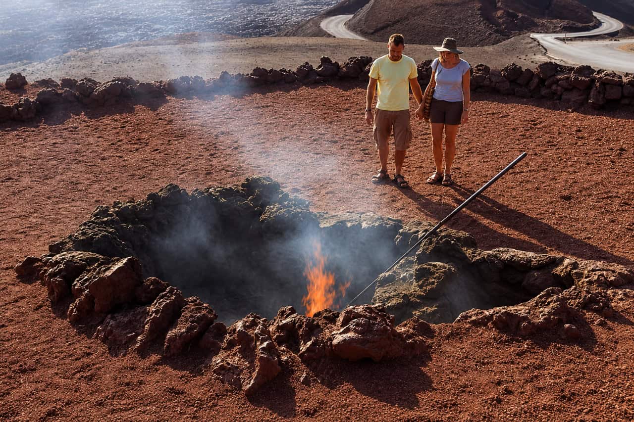 Family watching a geothermal demonstration at Timanfaya National Park in Lanzarote, surrounded by the island’s volcanic landscape.