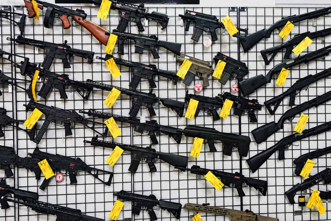 Airsoft Tenerife collectible card artwork, a wall of replica guns at the Las Chafiras arena