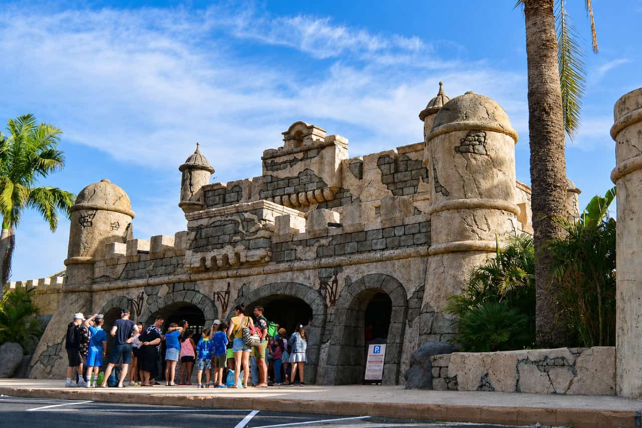 De kasteelachtige ingang van Aqualand Maspalomas, omringd door palmen