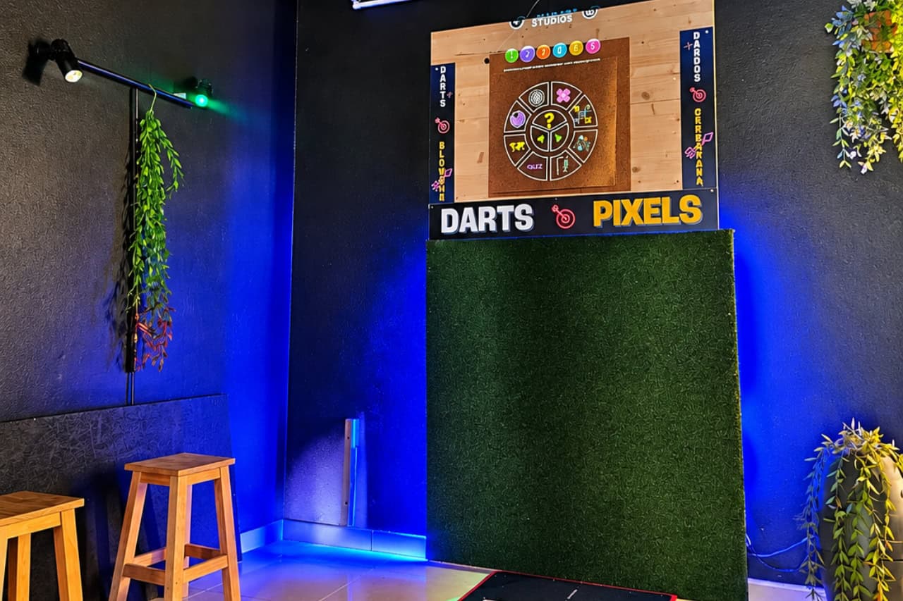 Interactive darts setup with digital target, throwing mat and blue lighting inside the axe throwing venue in Playa de Las Américas, Tenerife.