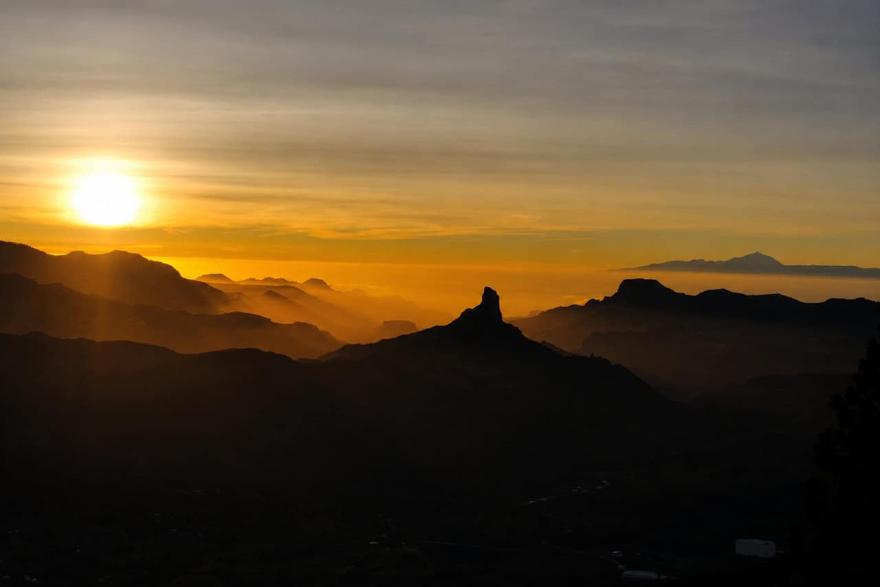 Goldener Sonnenuntergang, der die vulkanischen Berggipfel und Täler von Gran Canaria vor einem abendlichen Sternbeobachtungserlebnis erhellt.