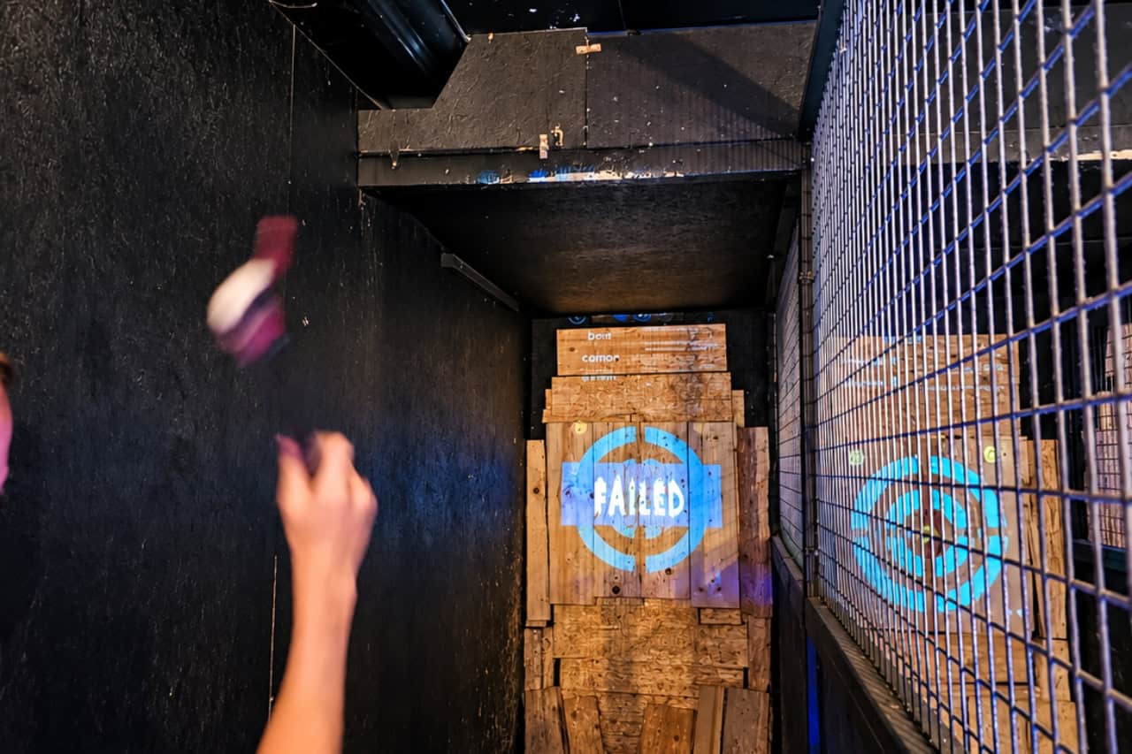 Grafika za zbirateljske kartice iz serije „Axe throwing Tenerife“, gost, ki vrže sekiro na digitalni tarčo v neonskem pasu