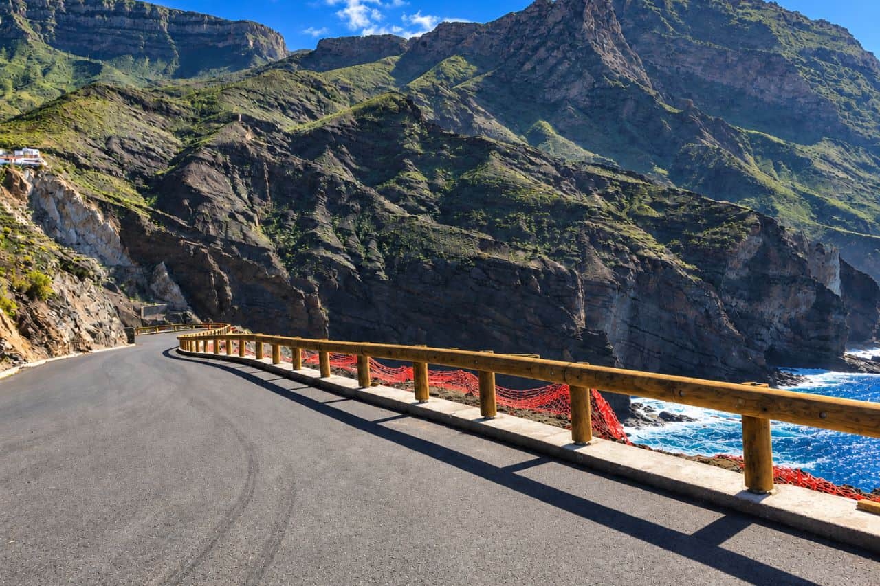 Empty winding coastal road through Tenerife’s rugged mountain landscape with dramatic cliffs and Atlantic Ocean views.