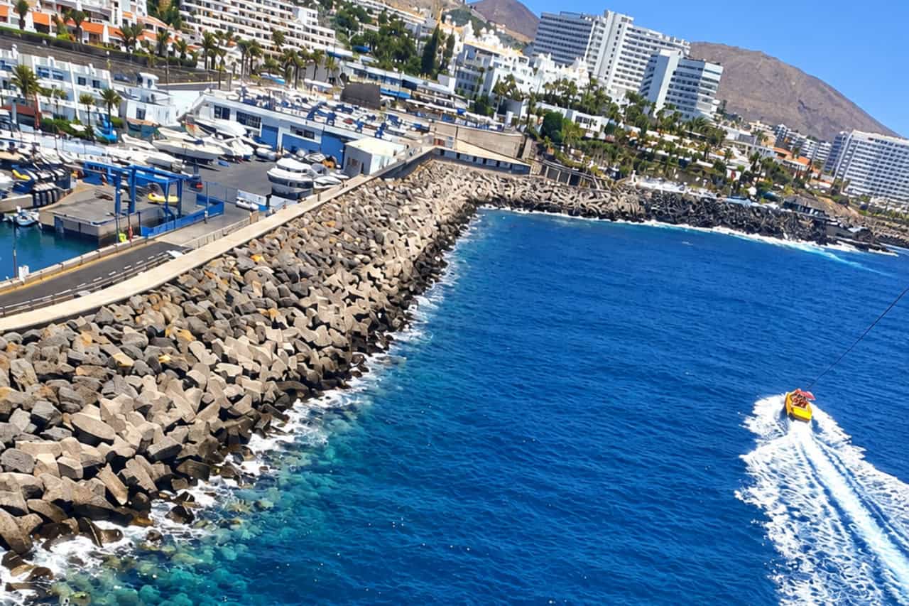 View from a parasailing flight over the coast of Costa Adeje with the yellow boat below