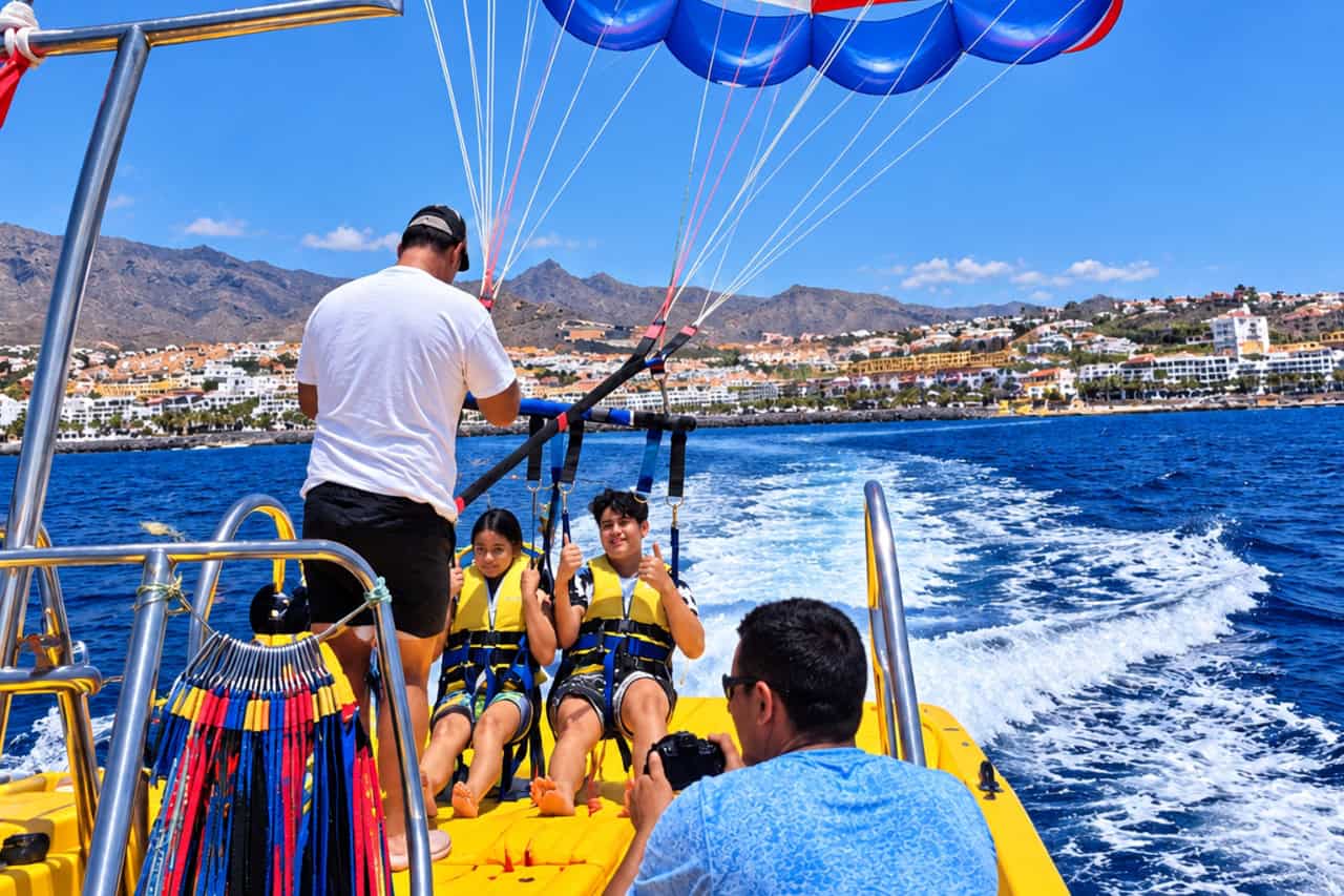 Two guests in harnesses on the boat deck ready for take-off off the Costa Adeje coast