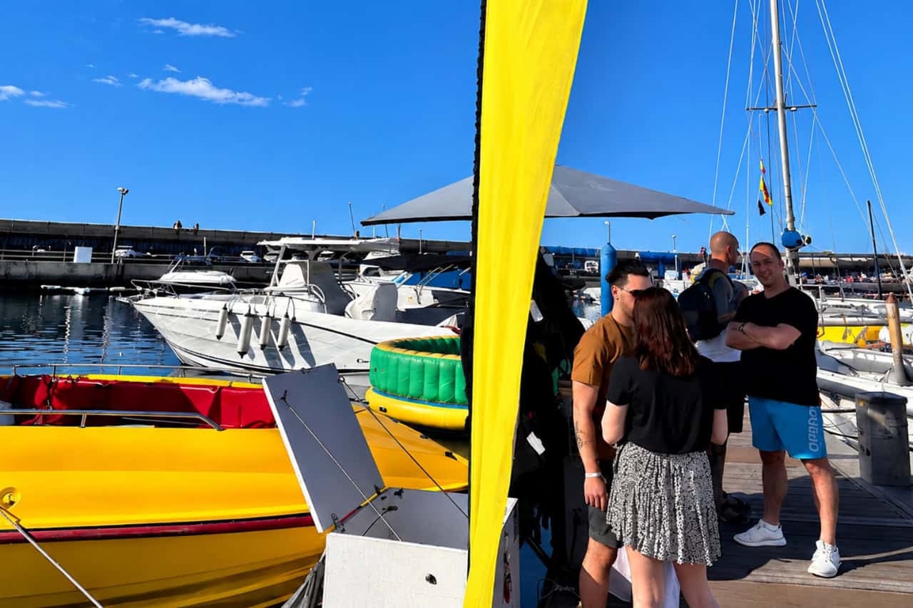 Guests meeting the crew beside the parasailing boat at Puerto Colon marina, Costa Adeje