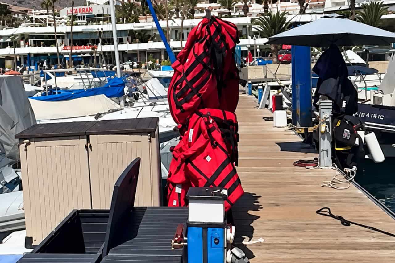 Red parasailing life jackets and harnesses ready on the dock at Puerto Colon, Tenerife