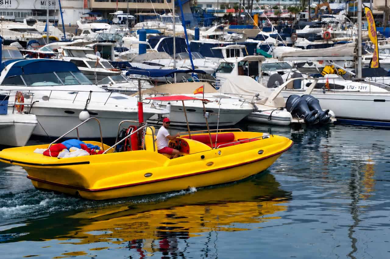 Yellow parasailing boat leaving Puerto Colon marina in Costa Adeje, Tenerife