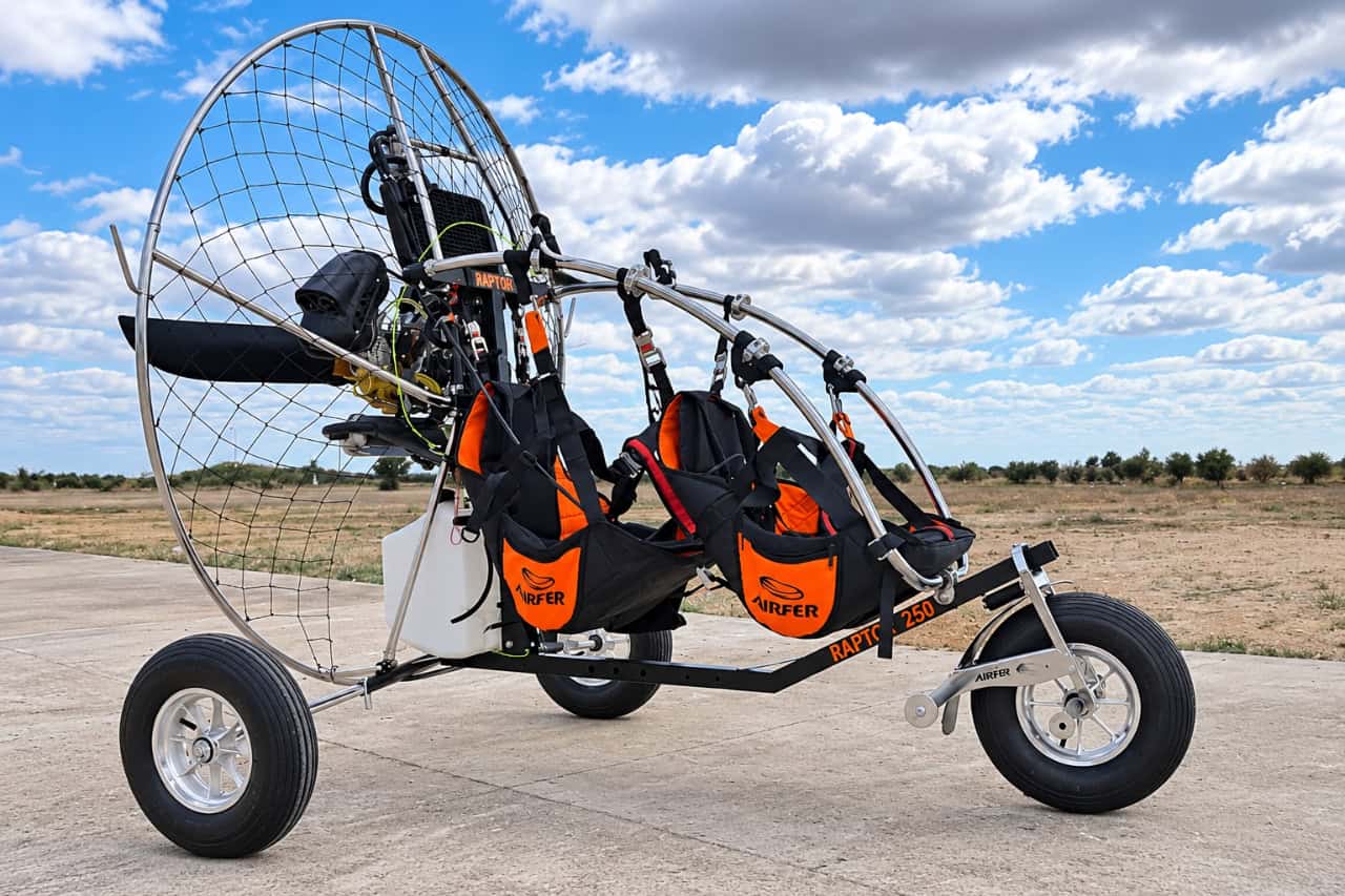 Two-seat paramotor trike with propeller cage and safety harnesses, ready for a tandem flying experience in Tenerife.