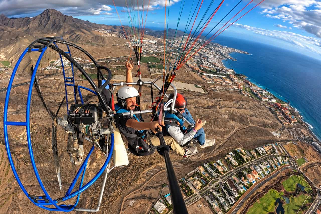 Tandem paratrike flight high above southern Tenerife with panoramic views of the mountains, coastal resorts and Atlantic Ocean.
