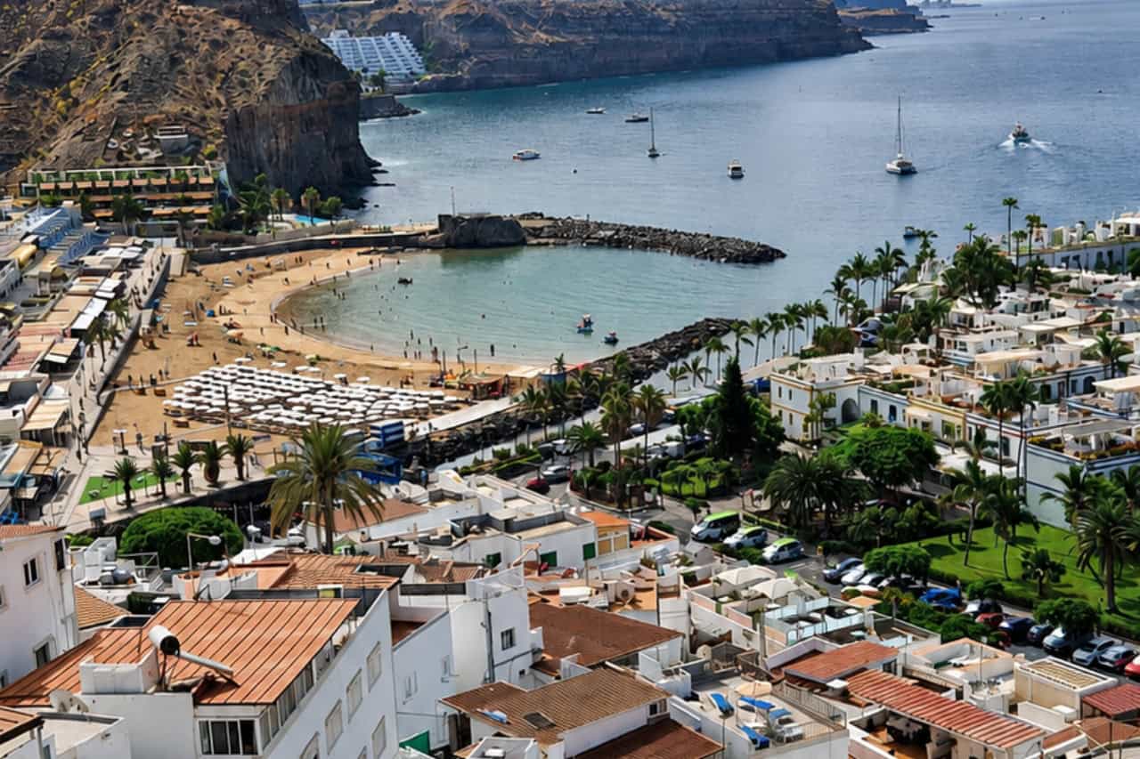 Panoramic view of Puerto de Mogán with its beach, marina, whitewashed houses and volcanic coastline during the Gran Canaria Island Day Tour.