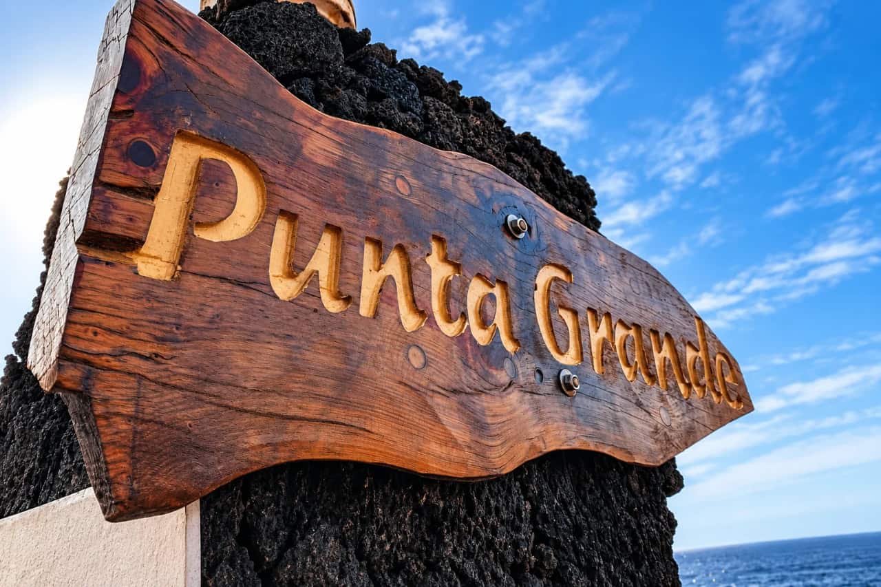 Wooden Punta Grande sign on the volcanic coast of El Hierro
