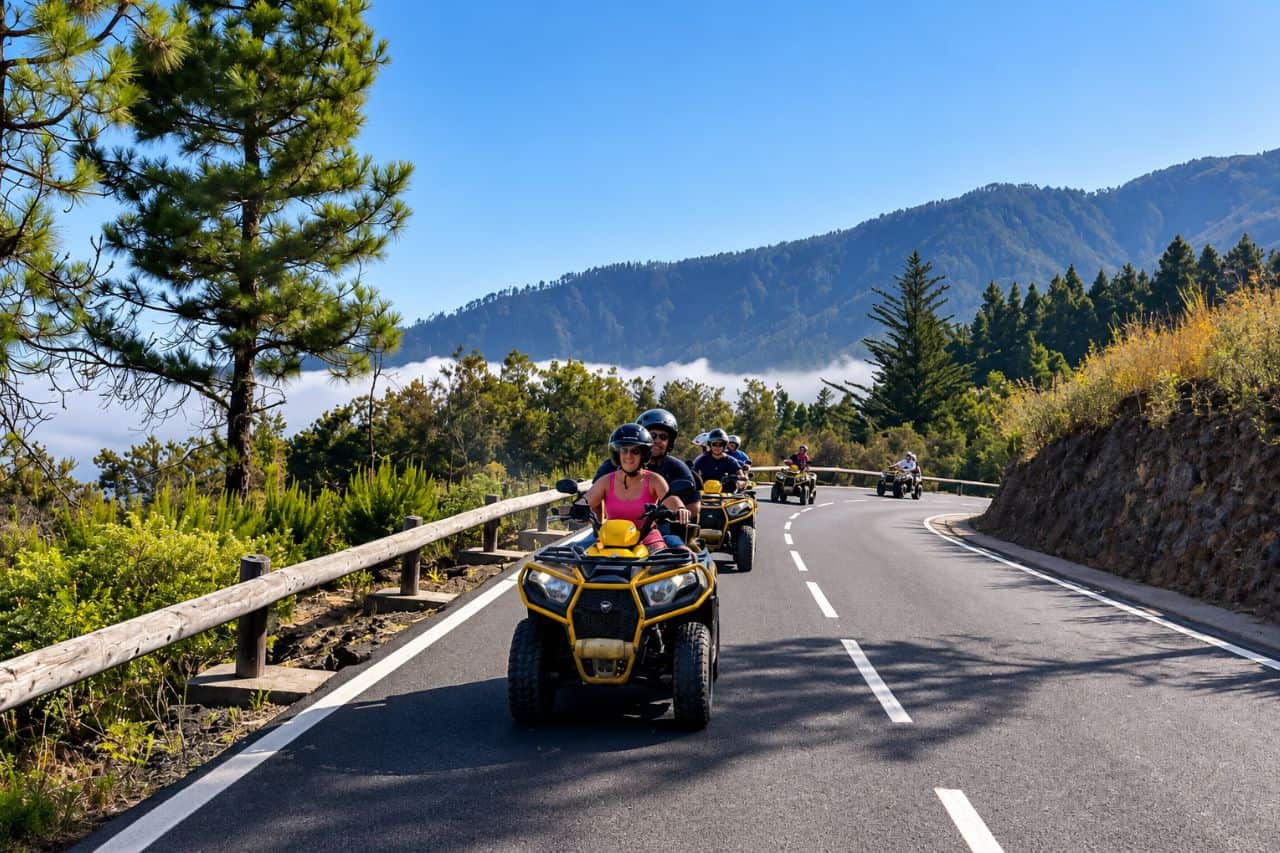 Group riding quad bikes along a winding mountain road through Tenerife’s pine forest during a guided quad tour from Puerto de la Cruz.