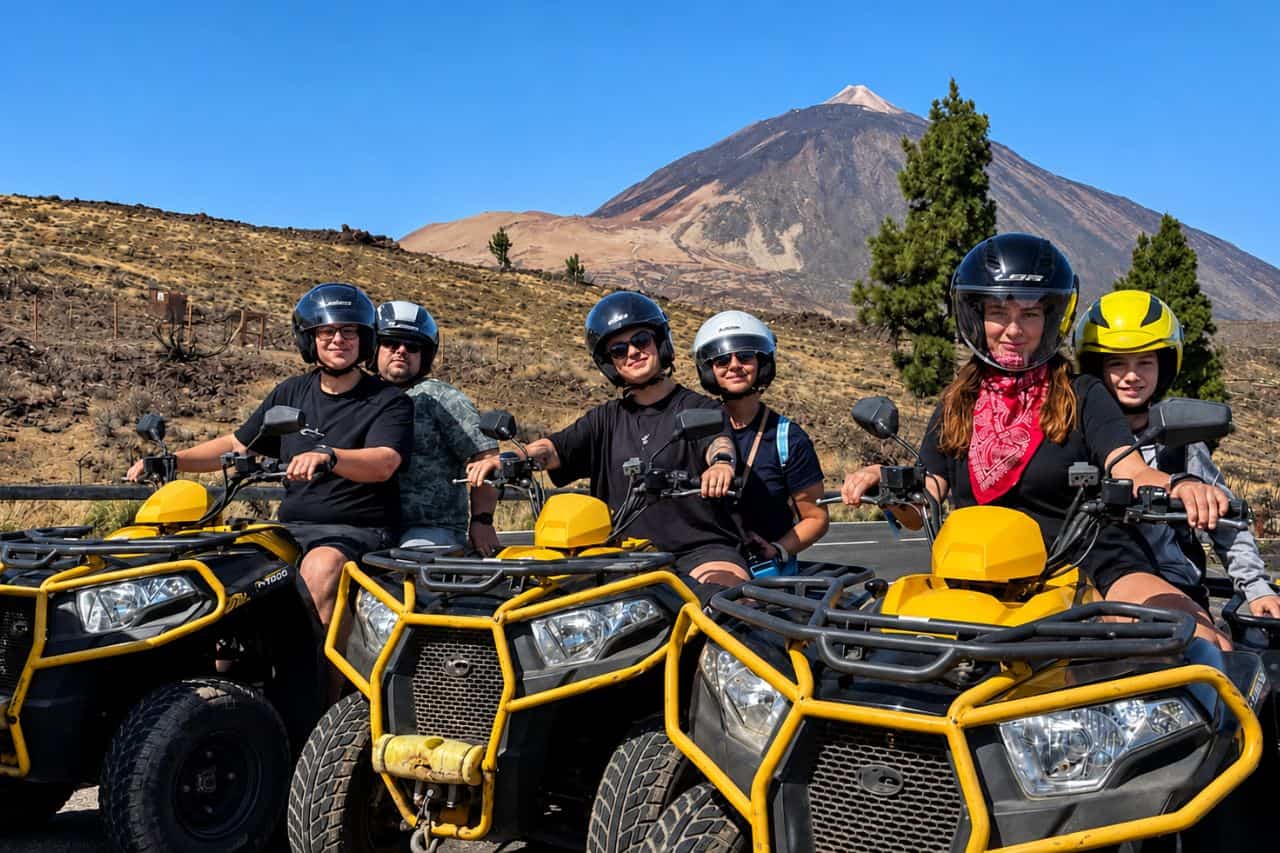 Group of riders posing on quad bikes with Mount Teide in the background during a guided quad tour from Puerto de la Cruz, Tenerife.