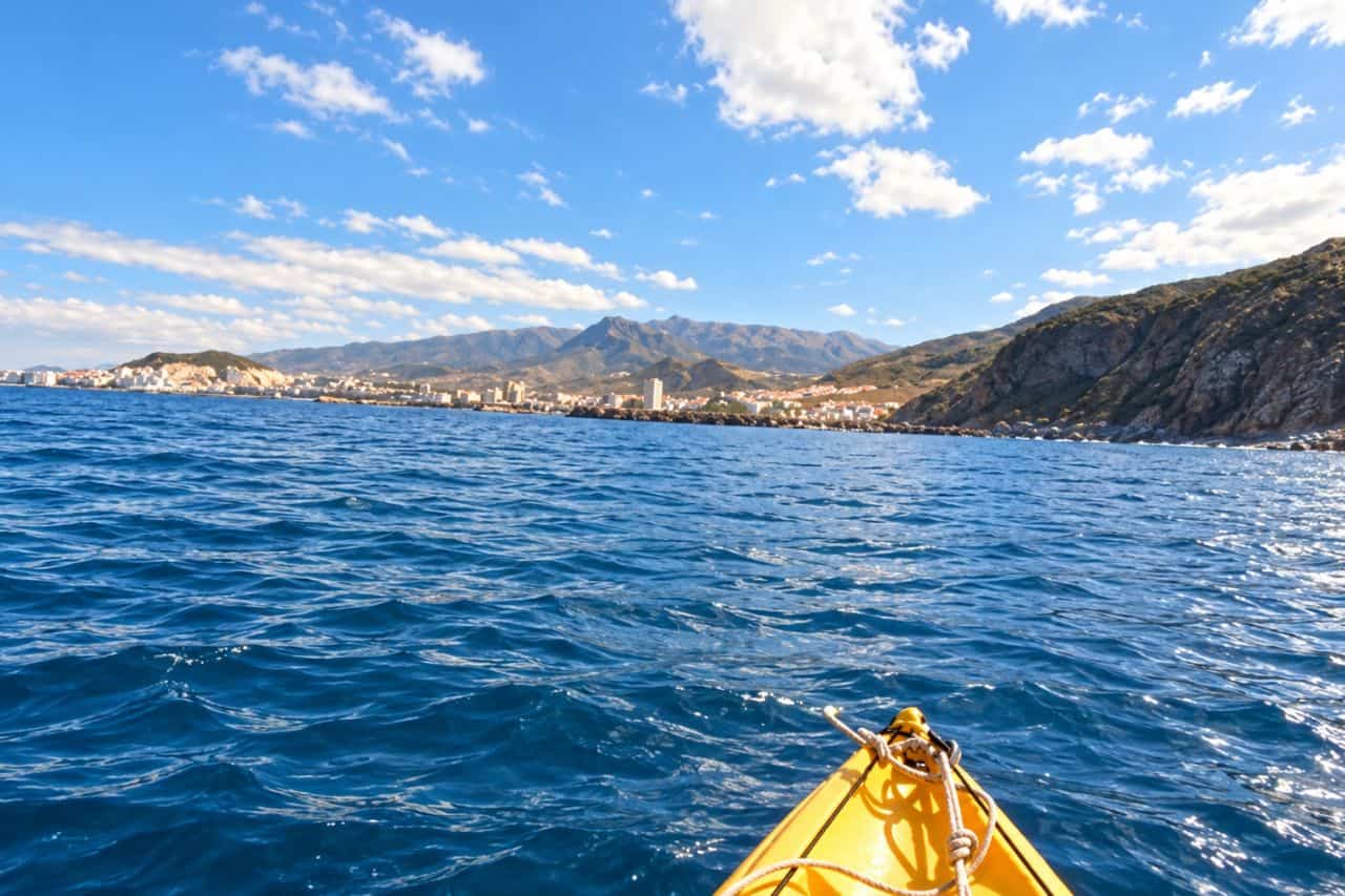 Kayaking Tenerife collectible card artwork, paddler view from a yellow kayak towards the coast and mountains