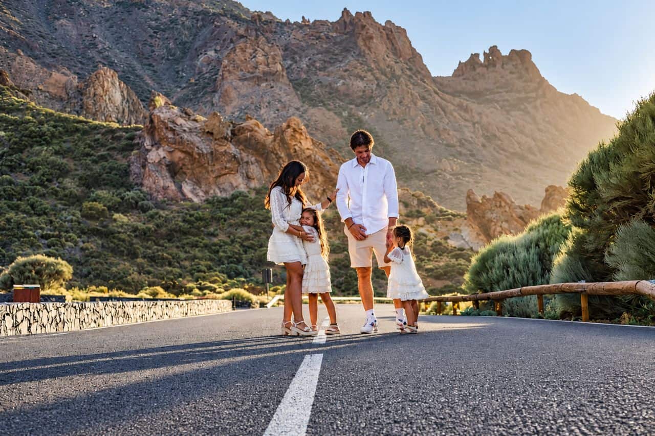 Een gezin van vier mensen loopt op een bergweg in het gouden licht tijdens een fotoshoot in Tenerife.
