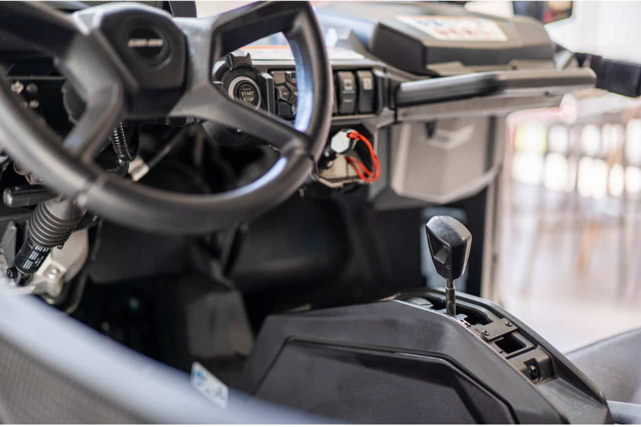 Close-up of the steering wheel, dashboard and gear selector inside a buggy