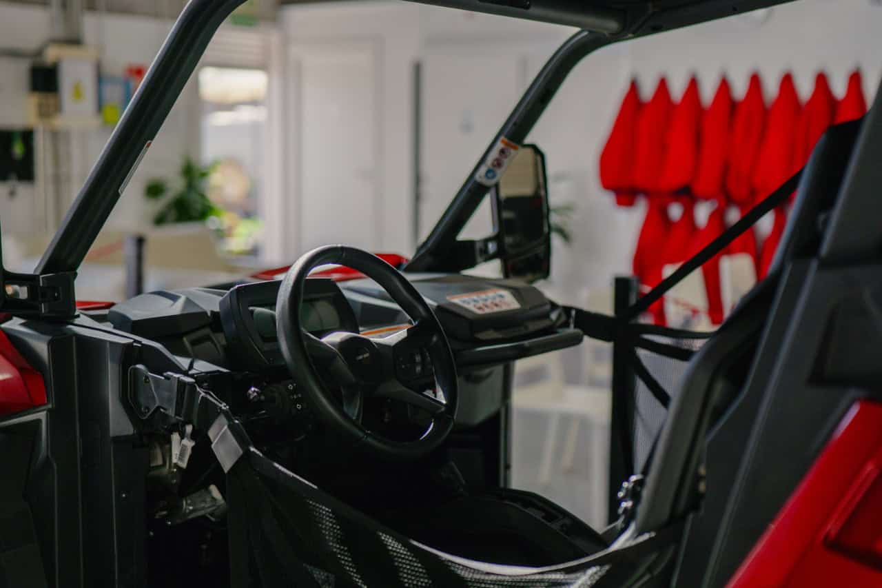 Driver cockpit of a buggy with steering wheel, dashboard and safety net