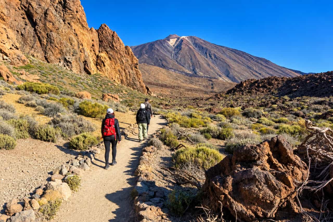 Private Teide tour from Santa Cruz collectible card artwork, walkers on a trail towards the volcano
