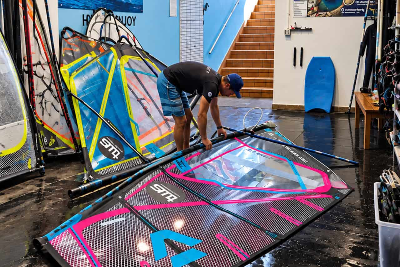 Instructor setting up a windsurf sail inside the surf centre in El Médano