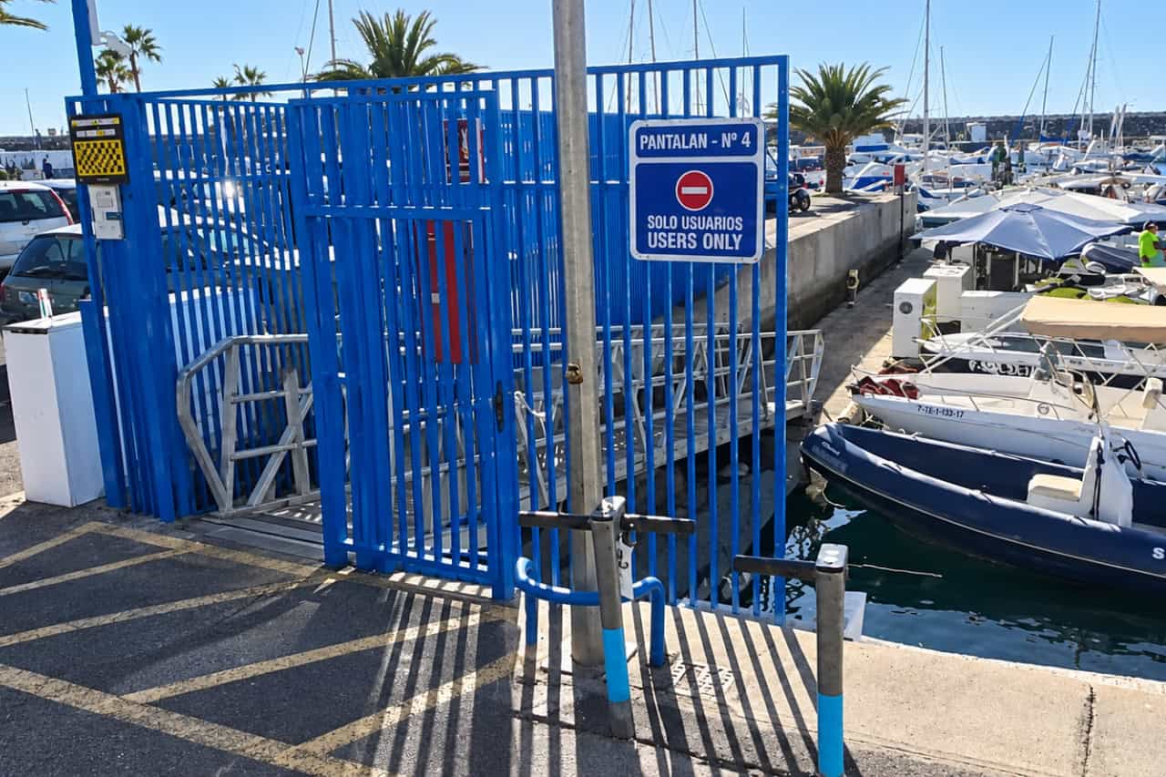 Blue entrance gate marked “Pantalán Nº 4” at Puerto Colón marina, the meeting point for parasailing in Tenerife.