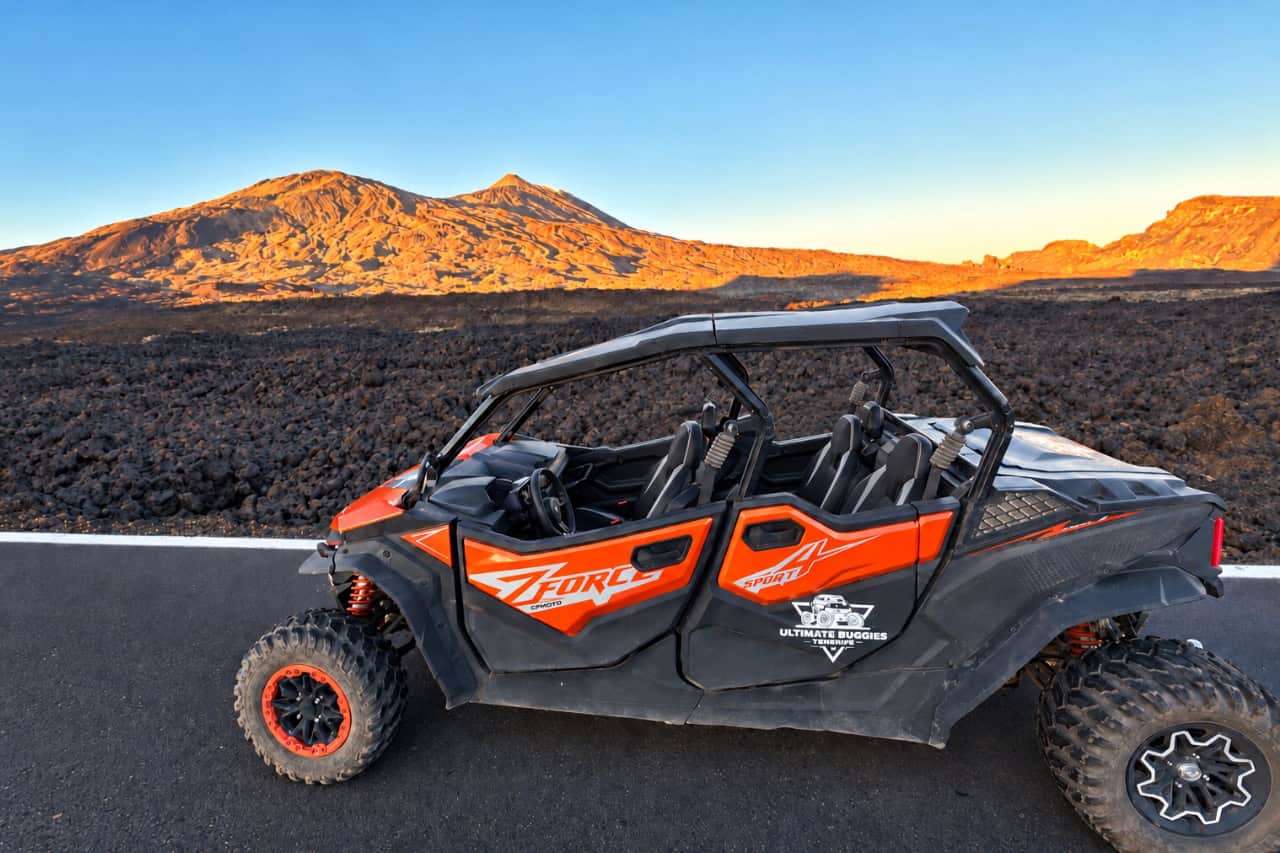 Orange four seater buggy parked on volcanic ground with Mount Teide behind